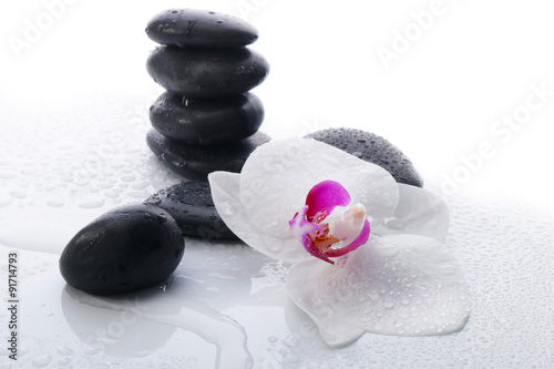 White Orchid and spa stones on a white background