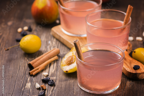 Homemade fruit compote with cinnamon on rustic wooden table. Selective focus