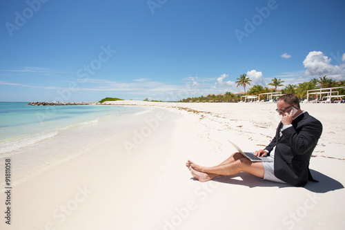 Busy businessman working on the beach