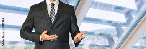 Man in business suit gestures with hands and says something