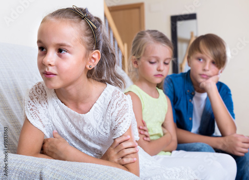 child sitting aside of boy and girl