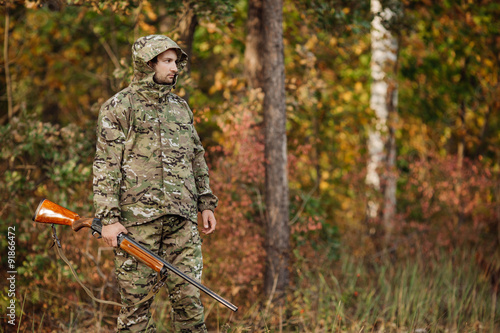Young male hunter in camouflage clothes ready to hunt with hunt