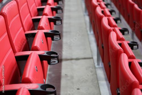 Red seats for fans on the tribune's sector of a modern football stadium