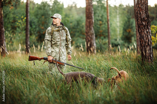 Yang Hunter z karabinem i psem w lesie