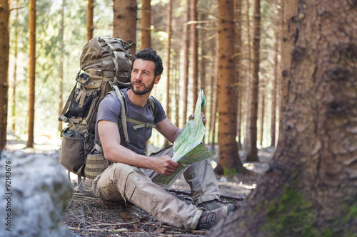 Man with Backpack and map searching directions