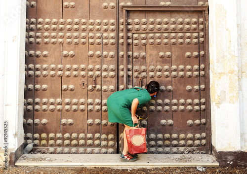 Woman looking through the keyhole, female curiosity