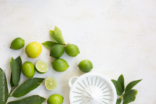 limes and a juicer on a white table