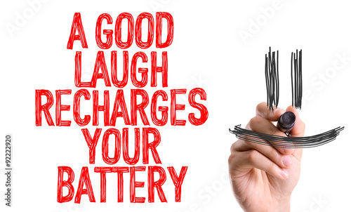 Hand with marker writing: A Good Laugh Recharges Your Battery