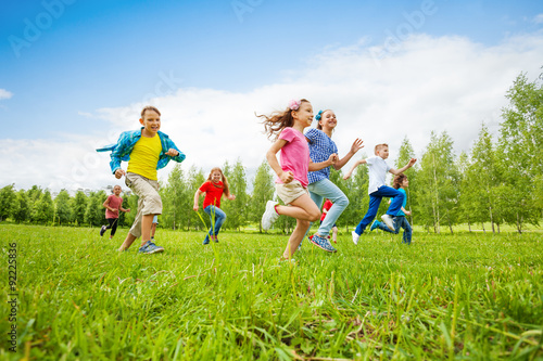 Children are running through green field together