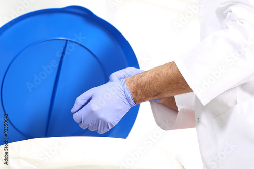 Odpady medyczne, lekarz chirurg wyrzuca rękawiczki do specjalnego pojemnika na odpady