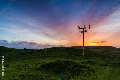 Telephone or electricity line in the fields at sunset