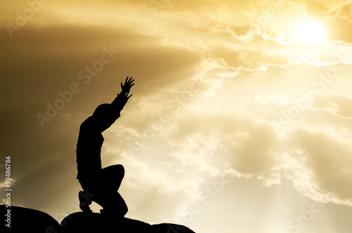 praying man on beautiful sky background