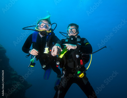 Romantic couple scuba dive together in the ocean 