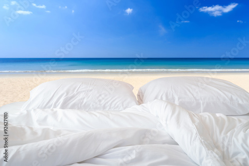 White bedding sheets and pillow on view of sky background