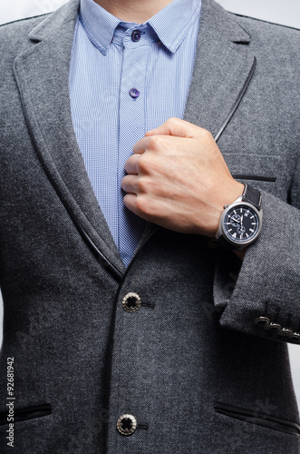 man in a suit shows a wristwatch
