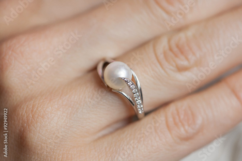 Woman's hand wearing a pearl ring