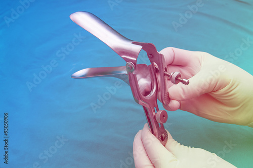 doctor holds a disposable speculum in his hand.