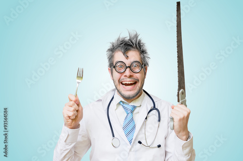 Funny wacky and crazy surgeon doctor holds unusual surgical instruments