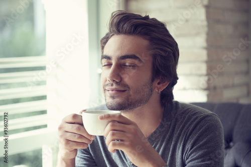 Young man drinking coffee in cafe