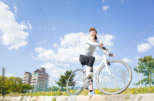 青空をバック 自転車に乗っている日本人女性