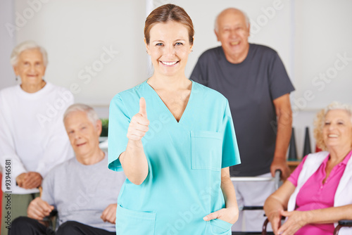 Krankenpfleger hält Daumen hoch vor Gruppe Senioren