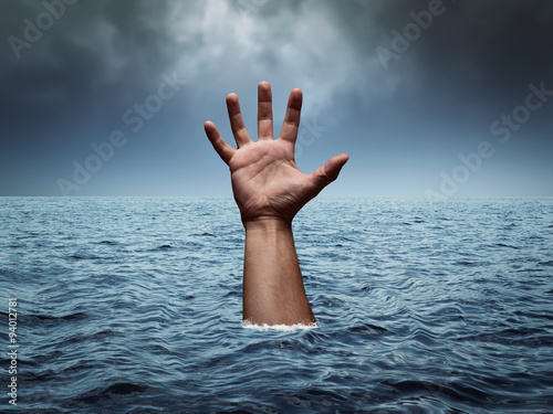 Drowning hand in stormy sea