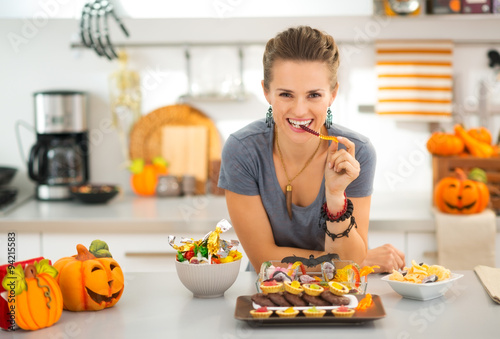 Smiling woman eating trick or treat halloween candy