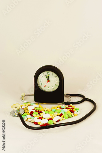 Tablets, medicines arranged in the form of heart with a stethoscope and a clock