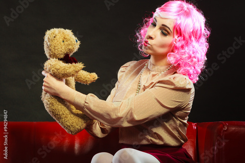 childlike woman and teddy bear sitting on couch