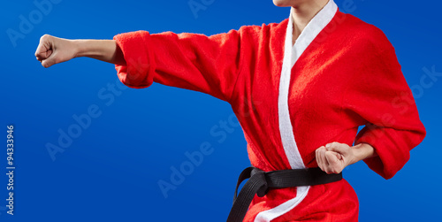 Girl in Santa Claus clothes doing karate kick