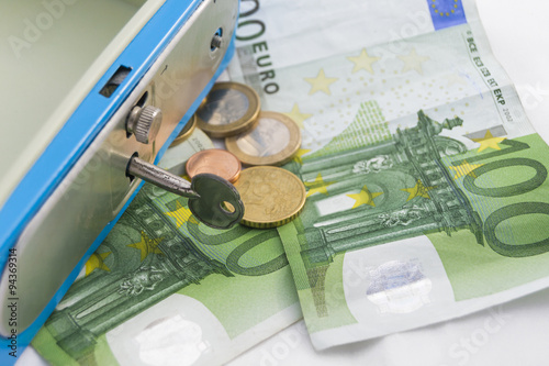 Billetes y monedas apilados de euro en una hucha