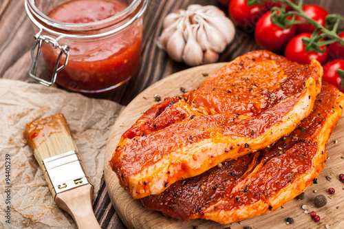 Marinated raw pork steaks on cutting board