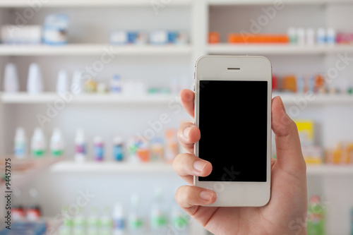 hand holding smart phone in drugstore