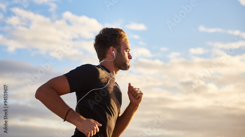 Man jogging on the beach with earphones