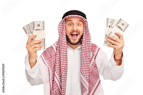 Excited young Arab holding few stacks of money