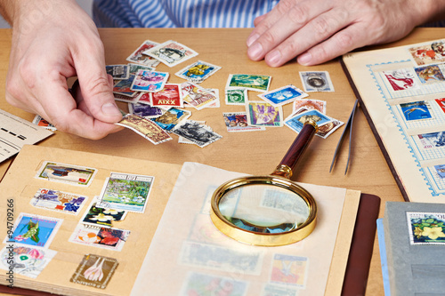 Man watching a collection of postage stamps