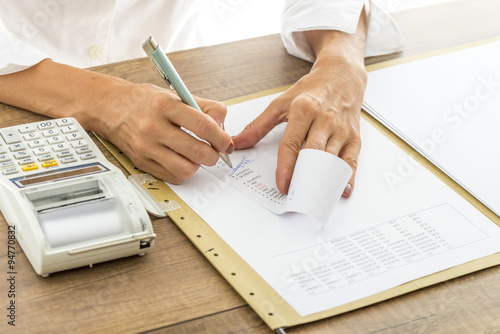 Female accountant calculating and reviewing numbers on a receipt