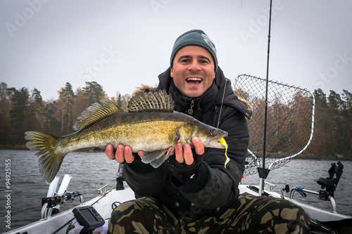Extremely happy angler with autumn walleye fish