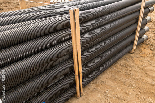 Stacked new PVC pipe on construction site