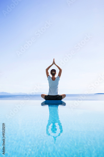 Young woman practicing yoga outdoors. Beautiful girl doing relaxation exercises. Harmony, balance, meditation, relaxation, healthy lifestyle, mindfulness concept