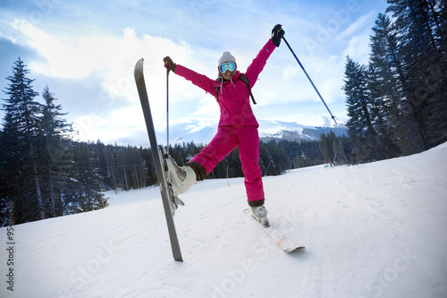 carefree young woman in ski suit