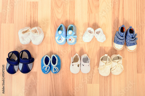 Baby boy shoes arranged on the floor. Tidy tiny child boots nicely arranged.
