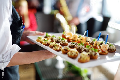 Waiter carrying plates with meat dish