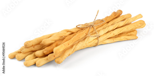 Toasted wheat long bread sticks, tied with a rope, isolated on a white background.