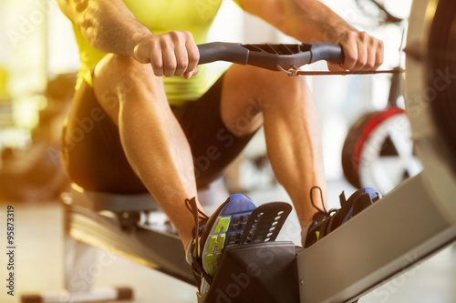 man training on row machine in gym