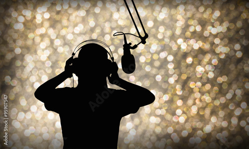 Entertainment background with silhouette of singing or singer with headphone and microphone on beautiful bokeh light in party and joyful event night or superstar search contest concept 