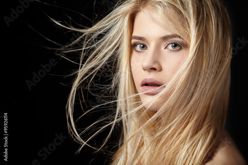 Beautiful young blonde girl with flowing hair. 