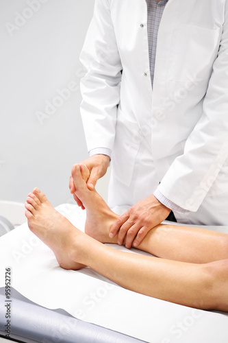 Złamanie kości stopy.Lekarz ortopeda, rehabilitant bada nogę pacjenta