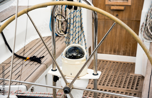 steering wheel and compass on a sailing boat