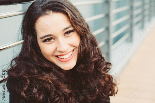 Portrait of a gorgeous brunette woman with wavy hair and beautiful smile